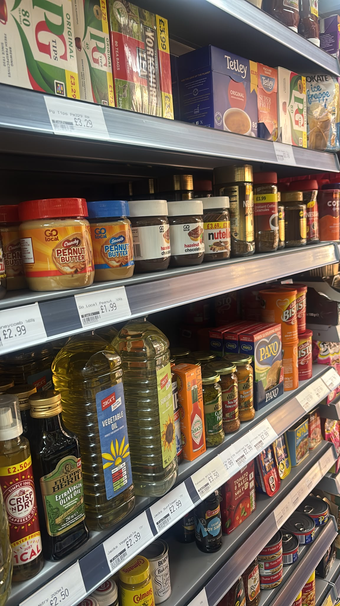 Shelves with tea, cooking sauces and cupboard essentials